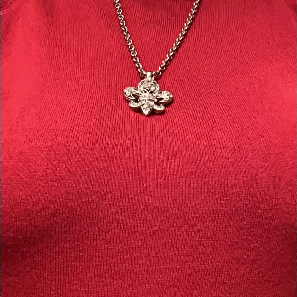 Silver plated fleur de lis necklace and earrings.